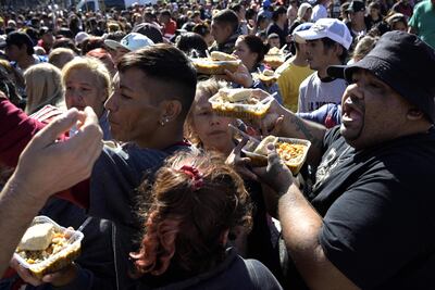 La gente forma fila para recibir un plato de comida en una olla popular sobre la avenida  9 de Julio Avenue donde organizaciones sociales y de izquierda se manifestaron contra el ajuste del Fondo Monetario Internacional (FMI).