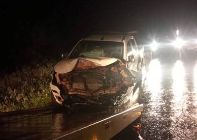 Uno de los vehículos involucrados es alzado en un camión grúa.