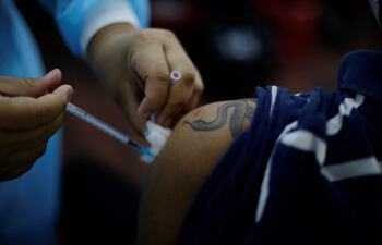 Un joven recibe su primera dosis de vacuna contra el covid-19 en San Salvador.