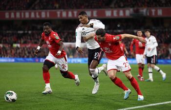 Marcus Rashford (C), delantero del Manchester United, procura abrirse paso entre dos jugadores del Nottingham Forest.