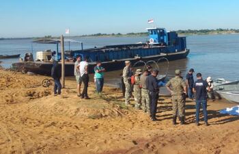 Efectivos de la Prefectura Naval y la policía Nacional llegan a la costa del río Paraguay con el cuerpo sin vida en Puerto Rosario para el procedimiento de rigor de la fiscalía