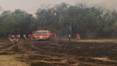 Los lugareños apoyan con baldes a los bomberos voluntarios.