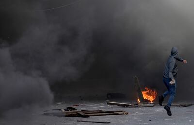 Un palestino lanza piedras durante un enfrentamiento tras una incursión militar israelí en la ciudad de Nablus, en el norte de Cisjordania, el viernes.