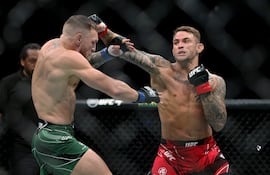 Poirier (d) lanza un golpe a McGregor (i), quien intenta defenderse.