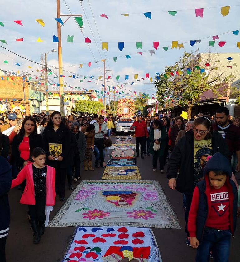 La procesión va pasando sobre las coloridas alfombras.