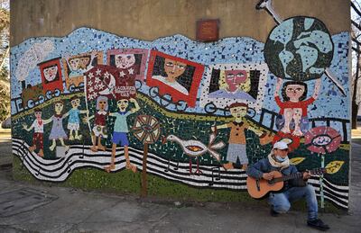 Leandro Bélen, de La Colifata, canta una canción de Manu Chao en frente de una fachada de la sede de la radio, el 30 de julio de 2021 en Buenos Aires (Argentina). La Colifata, la primera radio del mundo hecha por los pacientes de un hospital neuropsiquiátrico, cumple este martes treinta años en pleno estado de forma, con iniciativas que van más allá de los micrófonos y que buscan la solidaridad y la "inclusión económica" de los más vulnerables. A lo largo de las últimas tres décadas, la emisora creada por el psicólogo Alfredo Olivera ha colaborado activamente en la recuperación de cientos de enfermos psiquiátricos. Ahora ayudará a los colectivos más necesitados de Argentina, un país que atraviesa una profunda crisis económica y social desde mediados del 2018.