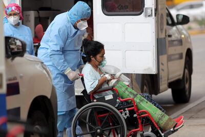 Imagen de referencia. Un paramédico lleva en una silla de ruedas a una paciente con sospechas de tener covid-19 hoy, afuera del Hospital San Felipe, en Tegucigalpa (Honduras).