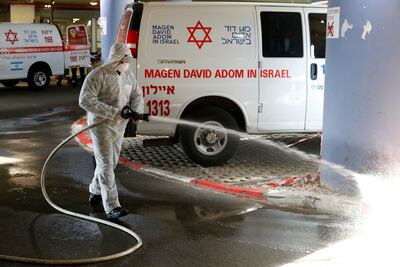 Un bombero israelí rocía desinfectante contra el nuevo coronavirus en el estacionamiento de emergencia en el Centro Médico Sourasky de Tel Aviv (Ichilov).