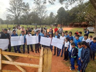 Los padres de familia y alumnos de ambas instituciones educativas se encuentran instalados en el portón de acceso.