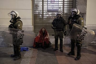 Policías custodian los alrededores donde se registran manifestaciones por la muerte de un joven en Grecia.