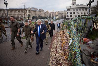 El primer ministro británico Boris Johnson (centro) y al presidente ucraniano Volodymyr Zelensky (2ndL) caminando frente a retratos de Heavenly Hundred Heroes, en el centro de Kiev hoy 9 de abril de 2022.