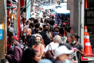Decenas de personas caminan en una concurrida vía comercial en el centro de Sao Paulo (Brasil).