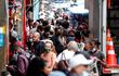 Decenas de personas caminan en una concurrida vía comercial en el centro de Sao Paulo (Brasil).