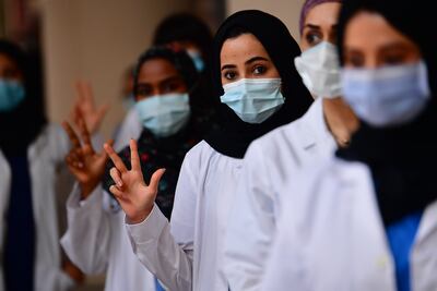 Trabajadoras médicas saludan en un hospital provisorio para tratar a pacientes con COVID-19 en Dubái, en los Emiratos Árabes Unidos.