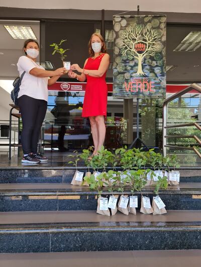 Nadia Czeraniuk (d), rectora de la UNAE, posa con los plantines de árboles y una de las voluntarias en la sede de la universidad.
