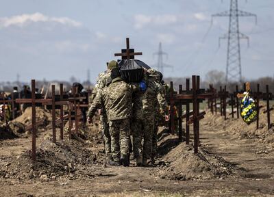 Soldados ucranianos cargan a hombros los ataúdes con los restos de sus compañeros, en un funeral y entierro colectivo celebrado hoy miércoles en el cementerio militar de Dnipro de veinticinco soldados muertos en el frente este de la guerra contra Rusia.
