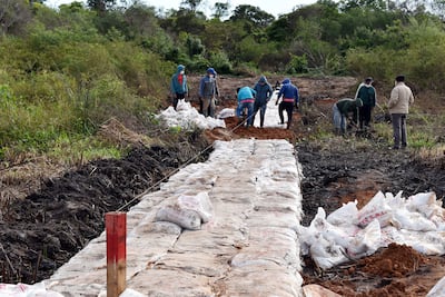 Obreros trabajan en la colocación de geobolsas en la cuenca del río Salado.