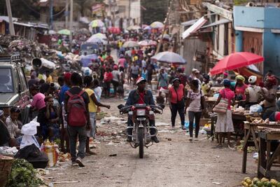 Personas circulan durante el atardecer por el mercado de Pétion-Ville, este domingo en Puerto Príncipe (Haití). La actividad en las calles de Puerto Príncipe no cesa con la caída del sol, a pesar del estado de sitio declarado por el Gobierno como consecuencia del asesinato del presidente Jovenel Moise, el pasado 7 de julio, que ha desencadenado una crisis de todavía incierta solución.