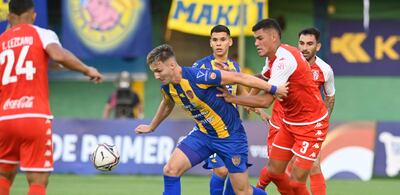 El centrodelantero argentino Paul Charpentier intenta conservar la posesión del esférico ante las presencias del zaguero central Manuel Romero Galeano y el lateral izquierdo Tomás Lezcano (24). En tanto, el extremo auriazul Julio Báez y el volante del Rojo,  Michael Leonel Pierce están atentos a la jugada.