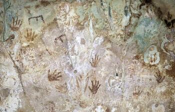 Una pintura rupestre en la caverna Kixné en un cenote de la Hacienda Kampepén, el 11 de noviembre de 2022, en el municipio de Homún (México). Manos pequeñas en positivo y negativo, un glifo como una especie letra E boca abajo y siluetas que adquieren formas extrañas, forman parte del mosaico de una pintura rupestre que se encuentra en uno de los tres cenotes de la Hacienda Kampepén, en Homún, municipio del estado de Yucatán, sureste de México.