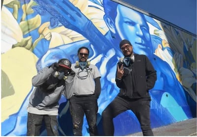 Los artistas frente al mural inaugura sobre la calle Montevideo.