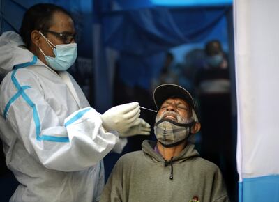 Una trabajadora de la salud toma una muestra de un hombre para una prueba de covid-19 en Kolkata, India.