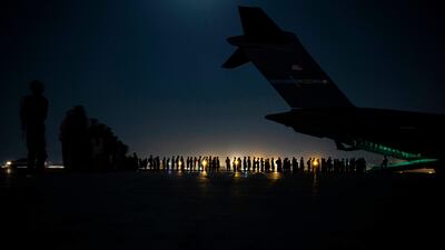 Varias personas hacen fila para abordar un avión de la Fuerza Aérea de los Estados Unidos en el aeropuerto internacional de Kabul, el pasado sábado.