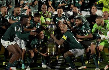 Gustavo Gómez y Felipe Melo, capitanes del Palmeiras, se disponen a levantar el trofeo rodeado de sus compañeros.