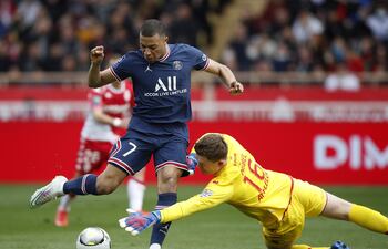 El arquero del AS Mónaco, Alexander Nubel (d), se dispone a tapar el remate de Kylian Mbappé, del París SG.