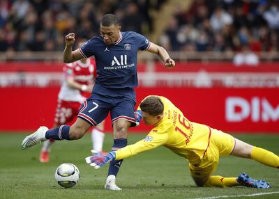 El arquero del AS Mónaco, Alexander Nubel (d), se dispone a tapar el remate de Kylian Mbappé, del París SG.