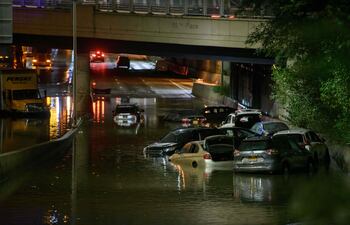Un trabajador destapa desagues en una calle inundada en Brooklyn, Nueva York.