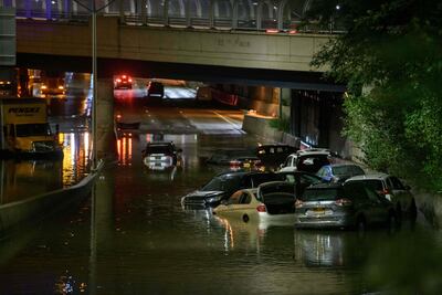 Un trabajador destapa desagues en una calle inundada en Brooklyn, Nueva York.