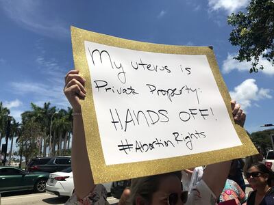 Una mujer sostiene una pancarta que dice "Mi útero es propiedad privada, ¡No lo toques!" durante un acto celebrado este martes a las afueras de la llamada Torre de la Libertad en Miami, Florida.