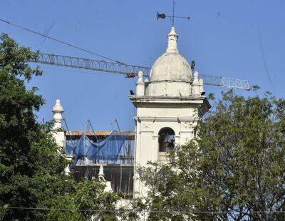 La enorme grúa y el edificio en construcción de la Universidad Católica se divisan por detrás de la fachada de la Catedral Metropolitana, sobre la calle Independencia Nacional. En primer plano, el campanario y la rosa de los vientos. Era una clásica postal asuncena, hoy arruinada.