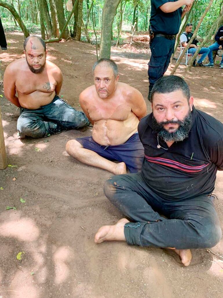   Leandro Hernandes de Souza (el primero de izquierda) ,  Lázaro Pereira Gomes Filho (centro) y Leandro Fontoura Cardozo, tras ser detenidos en una reserva cerca del río Paraná.
