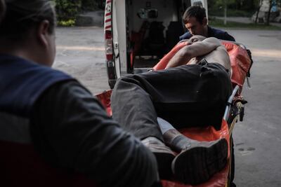 Personal sanitario traslada a un herido con una bomba, en una región de Ucrania.