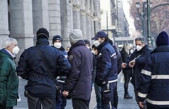 Policías de la compañía de transportes verifican el pasaporte covid de varios usuarios este lunes en Turín.