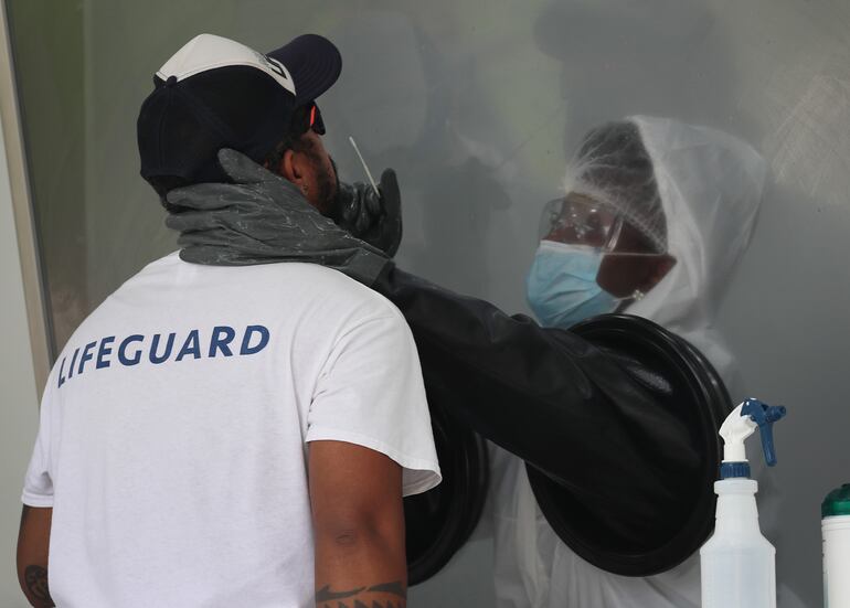 Una enfermera realiza una prueba de COVID-19 a un hombre en un sitio de tests móvil en Miami, Florida.