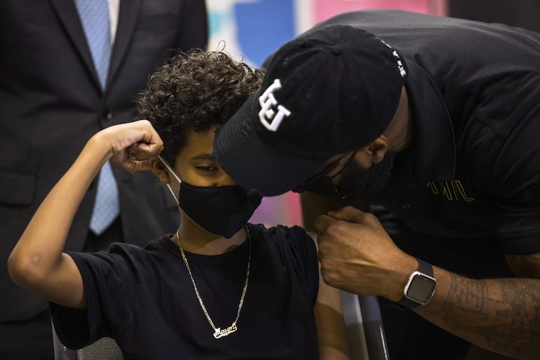Con un gesto de campeón Mason Lawrence, 9, se prepara para recib ir la vacuna contra el Covid en el Lower East Side en Nueva York.