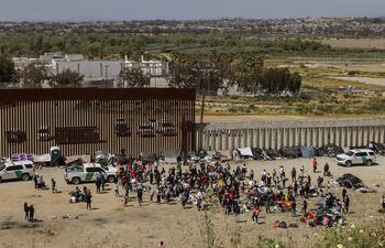 Fotografía general donde se observa a migrantes en un campamento junto al muro fronterizo, el 9 de mayo de 2023, en Tijuana, Baja California (México). Tan solo en Tijuana, en la frontera con California, miles de migrantes de diversas nacionalidades, incluyendo familias completas y niños se congregan entre los muros fronterizos días antes de que culmine el Título 42, la noche del jueves, para pedir asilo humanitario en Estados Unidos.