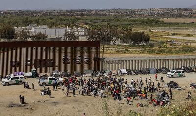 Fotografía general donde se observa a migrantes en un campamento junto al muro fronterizo, el 9 de mayo de 2023, en Tijuana, Baja California (México). Tan solo en Tijuana, en la frontera con California, miles de migrantes de diversas nacionalidades, incluyendo familias completas y niños se congregan entre los muros fronterizos días antes de que culmine el Título 42, la noche del jueves, para pedir asilo humanitario en Estados Unidos.