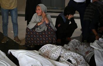 Familiares y parientes lloran dentro de un hospital, junto a los cuerpos de las víctimas que murieron en una explosión frente a una escuela en el distrito de Dasht-e-Barchi, Kabul.