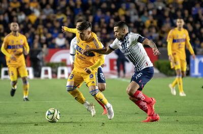 Fernando Gorriaran (i) de Tigres disputa el balón con Celso Ortiz de Rayados, durante un partido correspondiente a la jornada 12 del Torneo clausura 2023, en el estadio Universitario de la ciudad de Monterrey (México). EFE/ Miguel Sierra