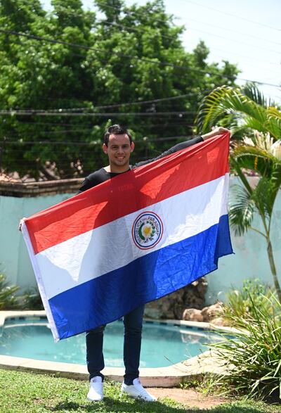 José Ariel López tras su llegada a Asunción exhibe su bandera paraguaya que lo acompañó en todo el viaje.
