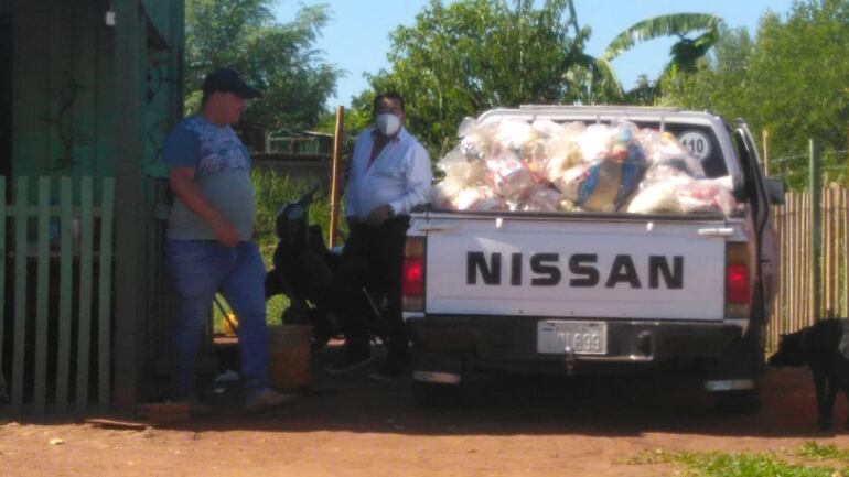 La foto de la polémica, el concejal Riquelme y el comunicador Arámbulo, con los víveres de la EBY.