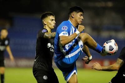 AME9504. VILLA ELISA (PARAGUAY), 20/05/2021.- Junior Osvaldo Marabel (d) de 12 de Octubre disputa un balón con Alexis Francisco Flores (i) de San Lorenzo hoy, durante un partido de la Copa Sudamericana entre 12 de Octubre y San Lorenzo en el estadio Luis Alfonso Giagni en Villa Elisa (Paraguay). EFE/Nathalia Aguilar