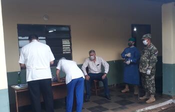 El intendente José Carlos Acevedo (sentado) siendo sometido a los controles sanitarios previos a su ingreso.