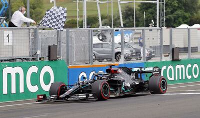 Bandera a cuadros para el británico Lewis Hamilton, quien cruza en primer lugar la línea de meta con su Mercedes.