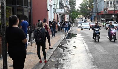 Varias personas esperando el transporte público en una de las paradas de la capital.