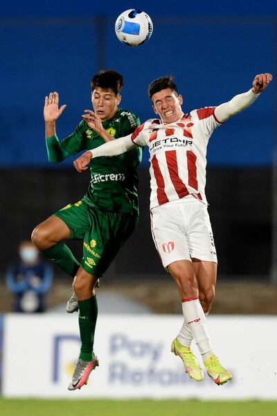 El zaguero paraguayo Juan Miguel Ojeda (i), del Cuiabá, salta en procura del balón ante Thiago Borbas, de River Plate de Uruguay, durante el partido que disputaron anoche en Montevideo.